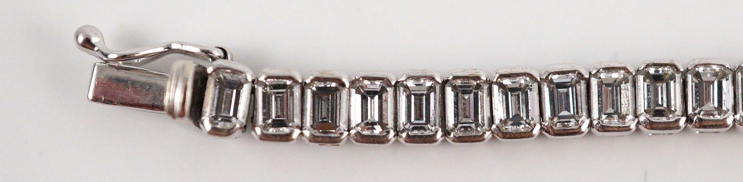 A modern 18ct white gold and emerald cut diamond set line bracelet